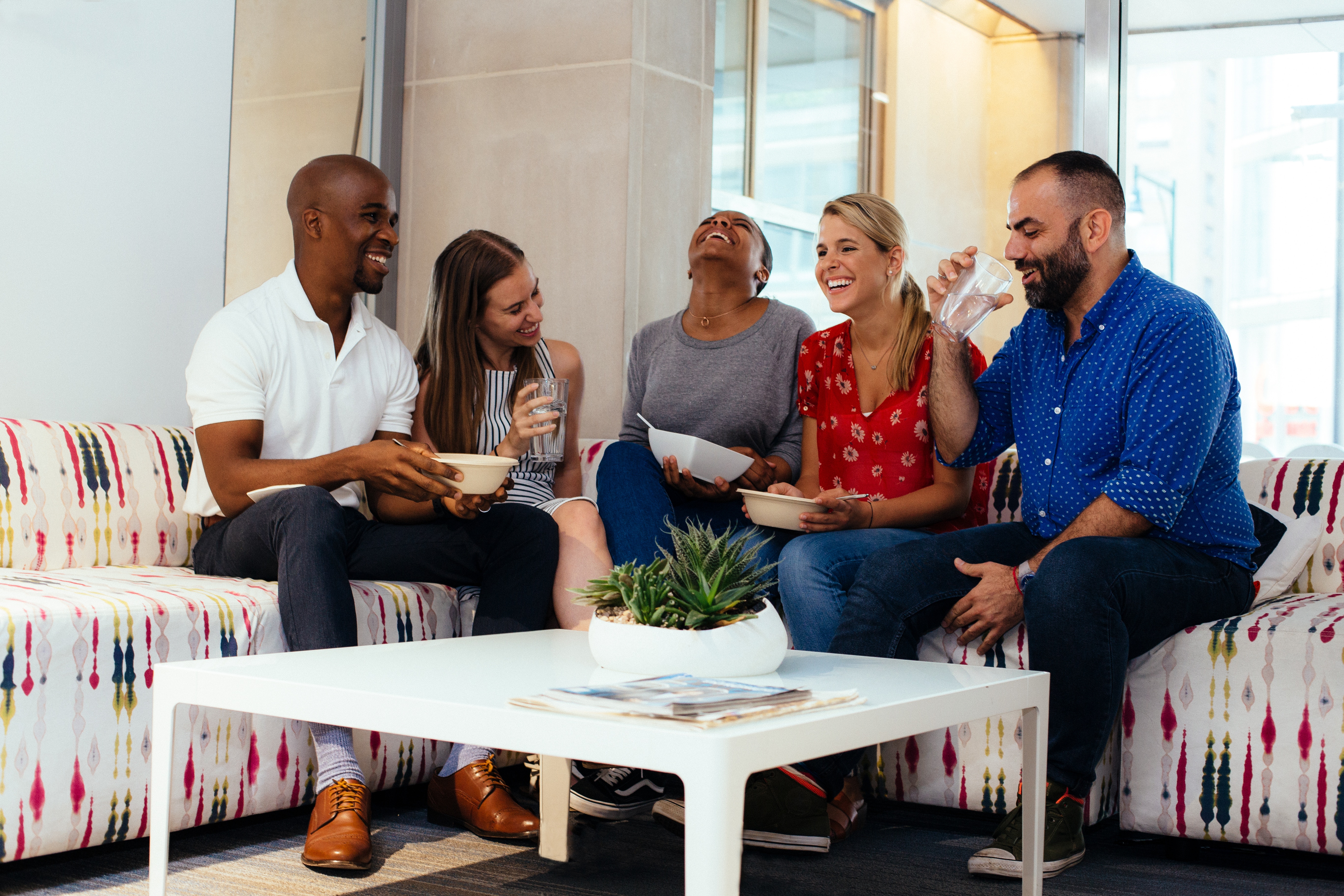 five person laughing each other in living room
